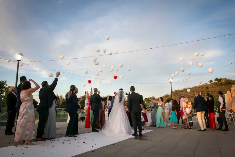 Una pareja y sus invitados celebrando una boda al aire libre.
