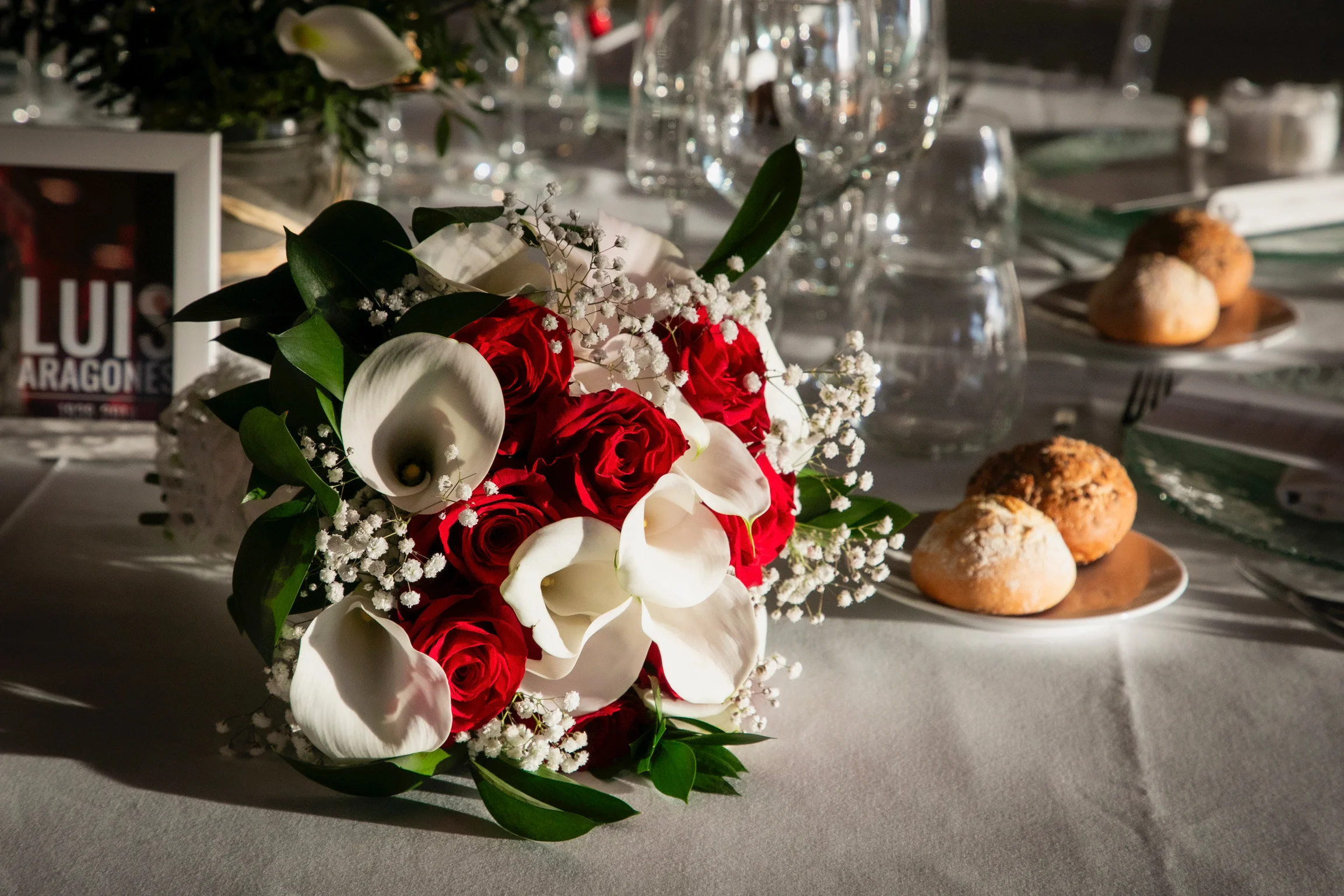 Detalle de flores rojas y blancas sobre una mesa de boda.